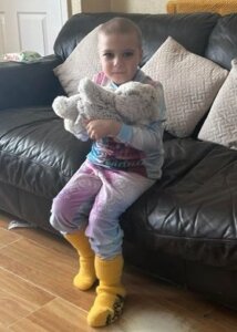 Four year old Nancy at home with her cuddly warmable bear