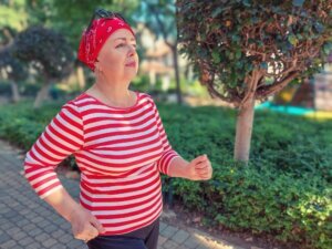 Mature woman wearing headscarf and striped jumper jogging